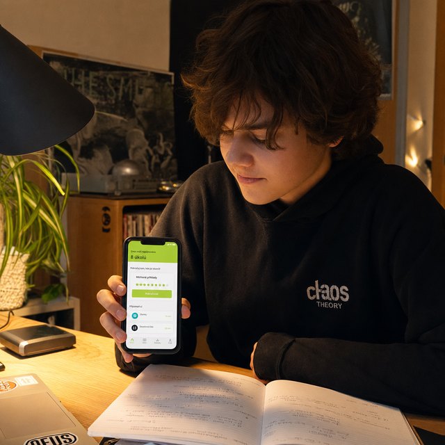 Český středoškolák studuje večer ve svém pokoji s aplikací StudeX v ruce.